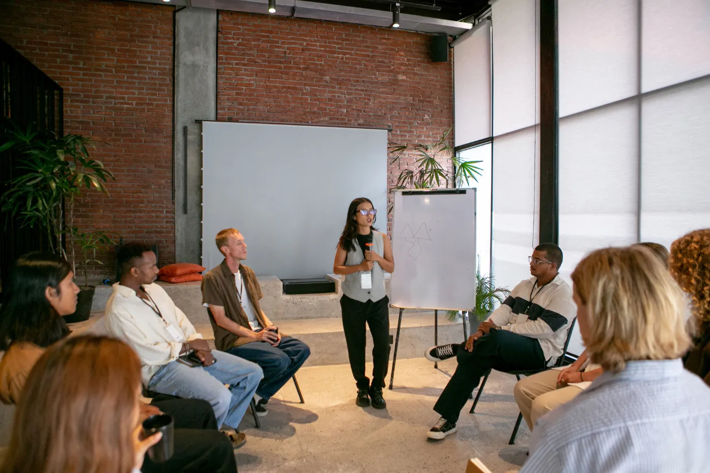 Facilitator leading a small group discussion with participants seated in a circle during an interactive workshop.