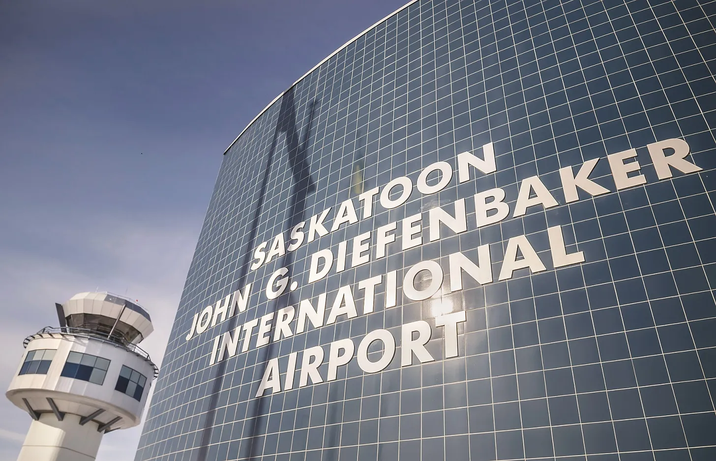 Exterior view of the Saskatoon John G. Diefenbaker International Airport terminal with the control tower in the background.