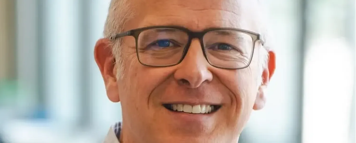 David Wiley - smiling white middle-aged man with closely cut light hair wearing a white button-down shirt and glasses.