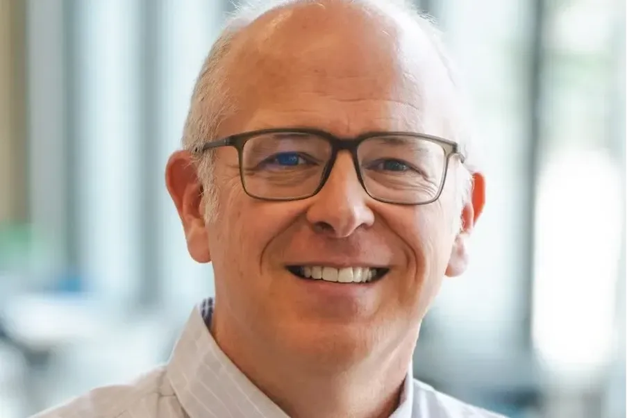 David Wiley - smiling white middle-aged man with closely cut light hair wearing a white button-down shirt and glasses.