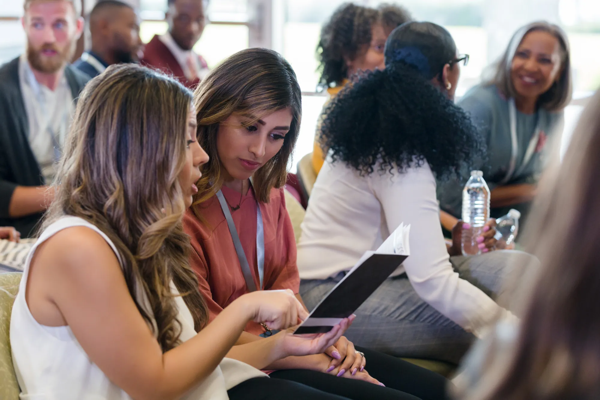 Participants engage in conversation and review conference materials during a networking session.