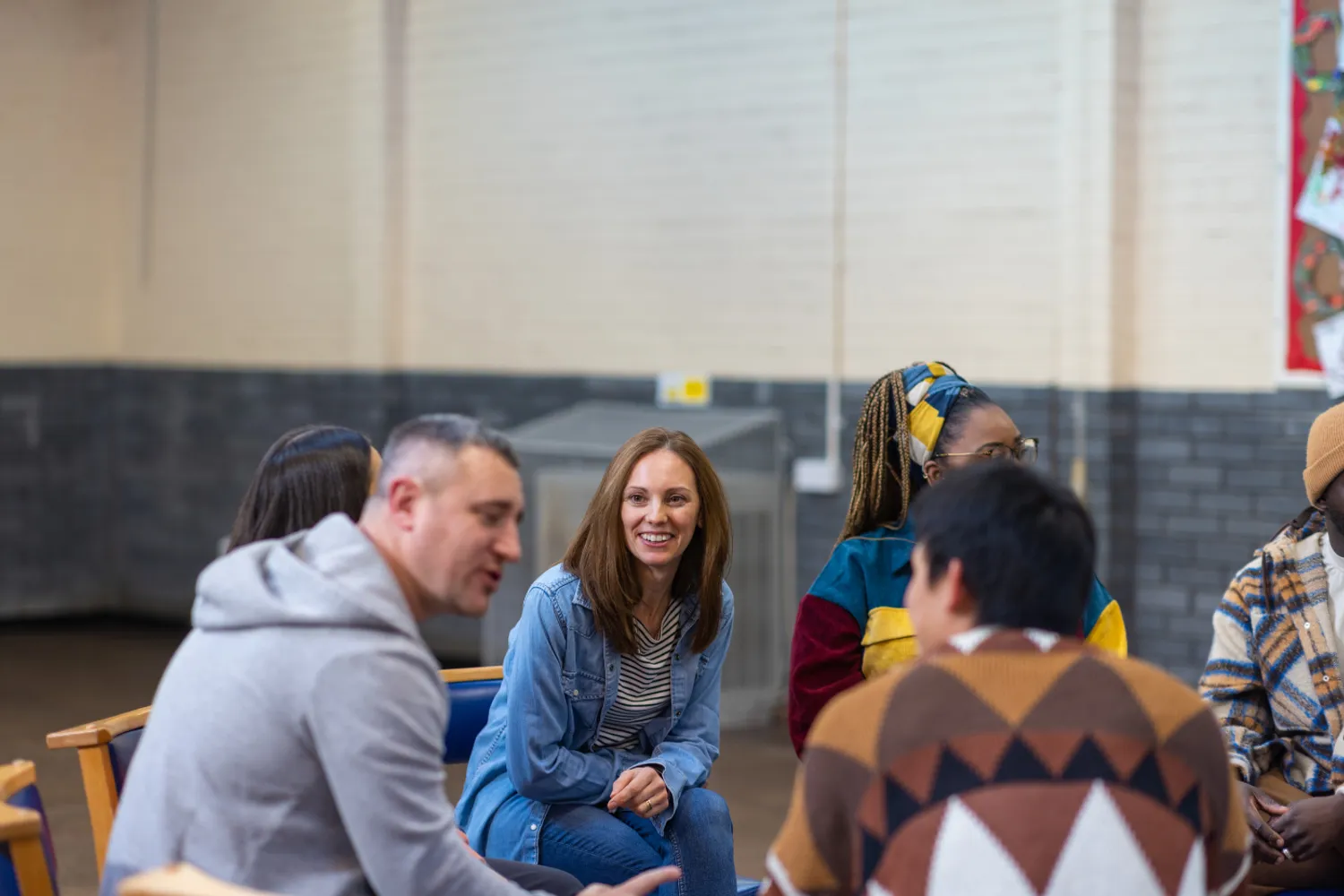 Small group of participants seated in a circle, engaged in conversation during a collaborative discussion session.